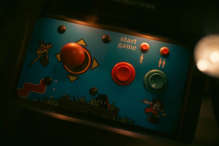 Régi játéktermi kezelőpanel joystickkal és színes gombokkal.